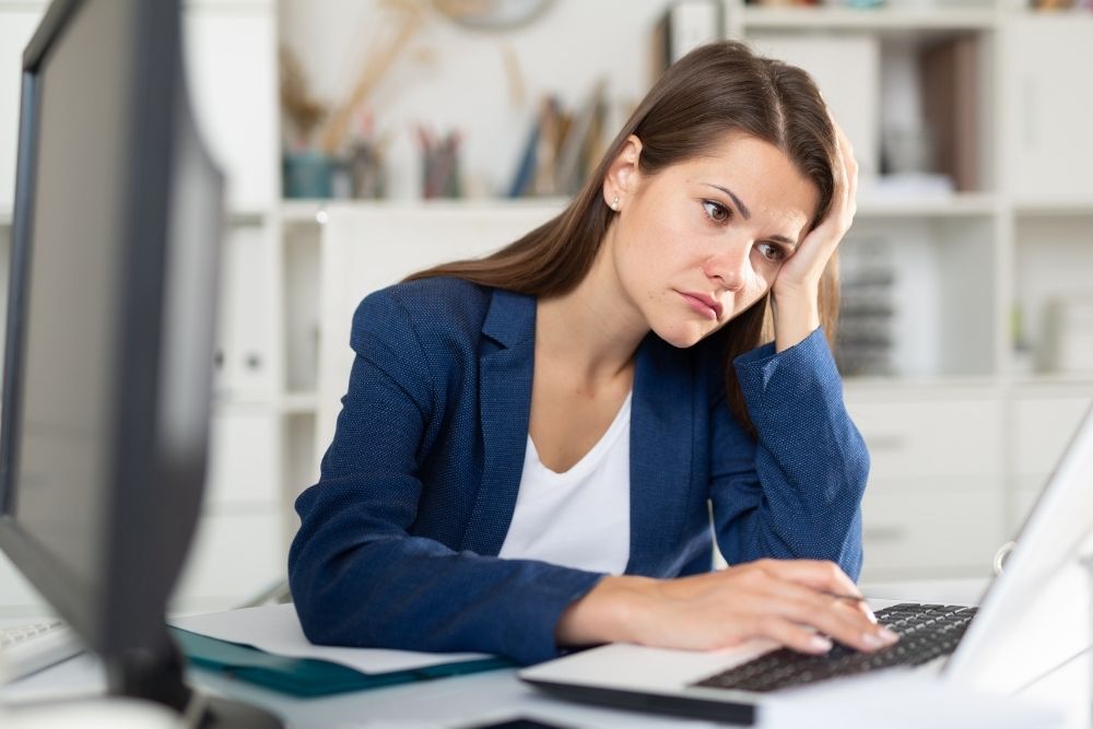 A frustrated business owner looking at a broken website due to neglecting a website maintenance plan, including downtime and revenue loss