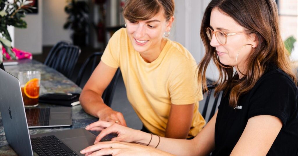 Two women managing a website maintenance plan to keep sites secure and optimized
