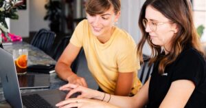 Two women managing a website maintenance plan to keep sites secure and optimized