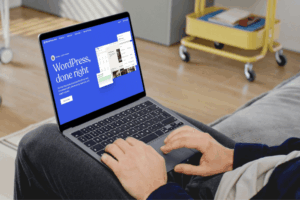 Man using a laptop with WordPress homepage on screen, representing WordPress vs Wix comparison.