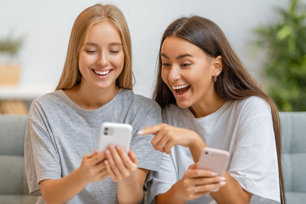 Two woman checking if their business website is mobile responsive.