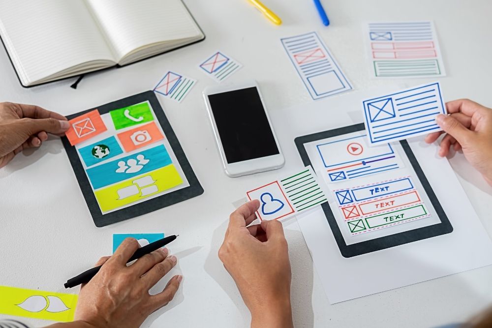 Web designers designing a mobile responsive website layout for local businesses.