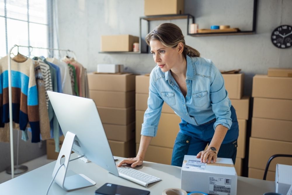Small business owner managing weekly marketing tasks and tracking Google Reviews at a desk.