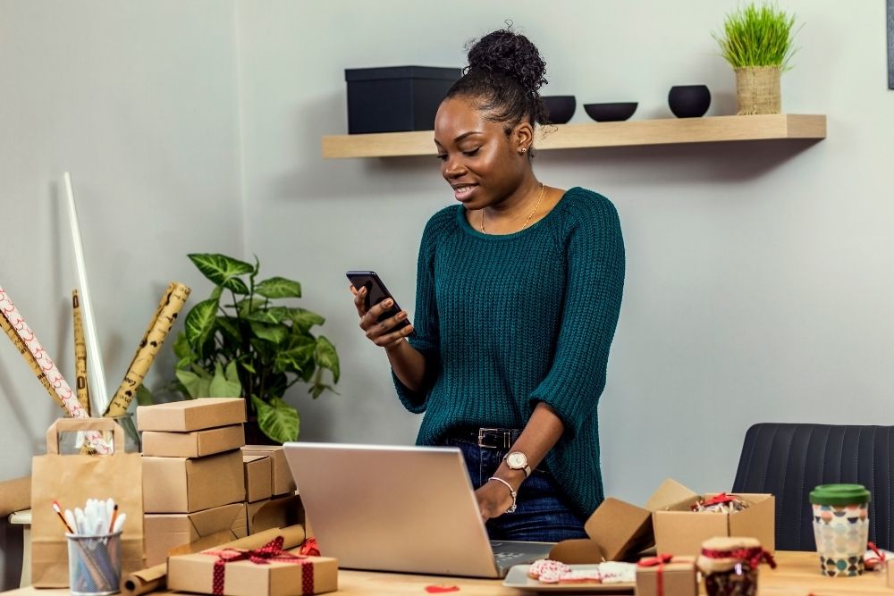 Small business owner typing an automated text message to improve lead response time.