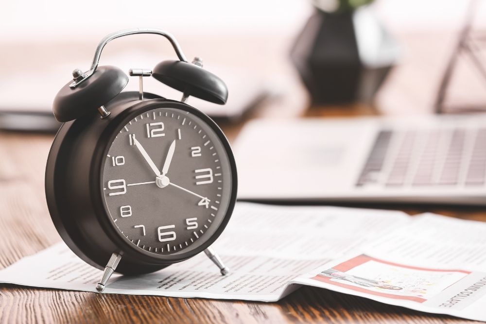 Alarm clock and notes illustrating data on speed-to-lead benchmarks and lead response time.