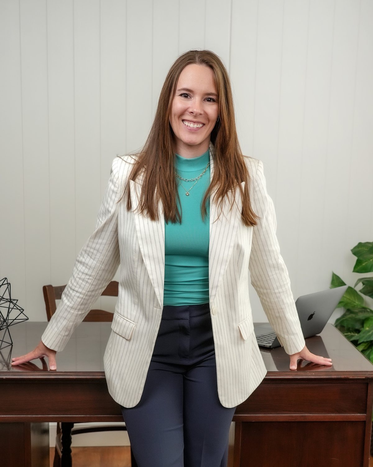 Megan Dornbusch leaning against her desk and smiling